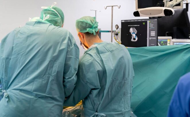 two surgeons are proving hip replacement operation for their patient.