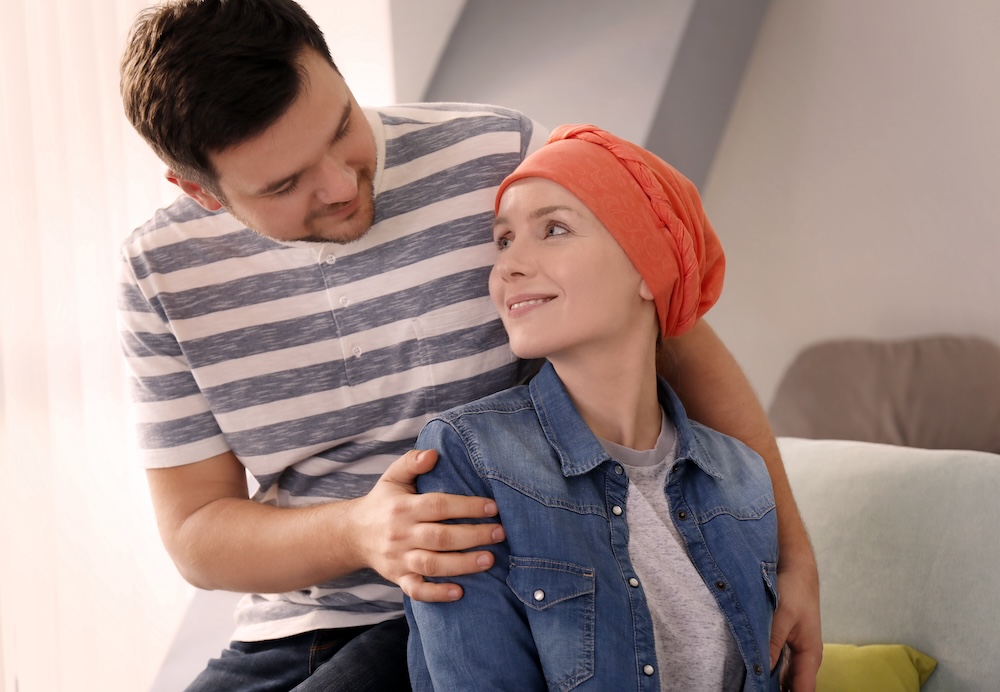 Young man visiting his wife with cancer indoors